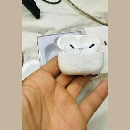 White wireless earbuds in charging case held in hand on marble background
